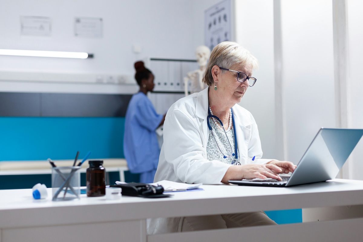 Doctor adding data on a digital device